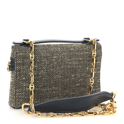 Mini herringbone pouch with long gold chain strap, navy leather bottom panel, zip