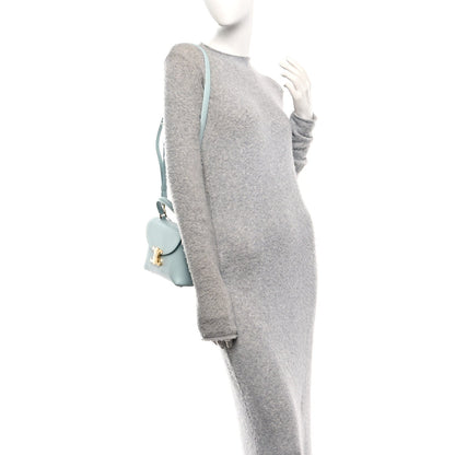 Light blue leather crossbody bag on mannequin with front flap and strap