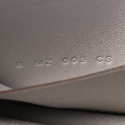 Embossed serial/markings on pale gray leather interior surface