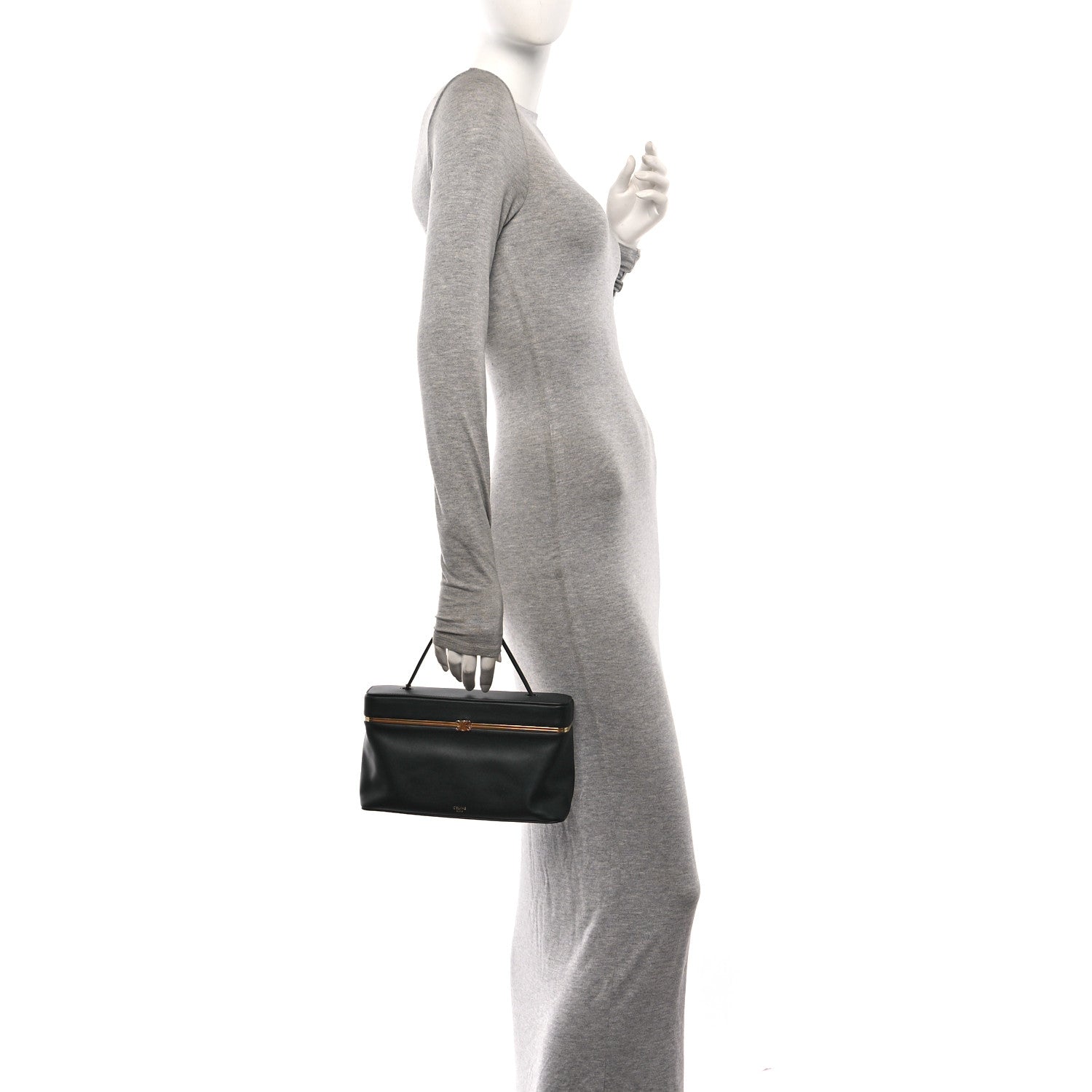Celine black rectangle bag worn by model, with top handle and gold-tone clasp