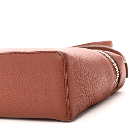 Side close-up of grained calfskin pouch with zipper edge and rounded base
