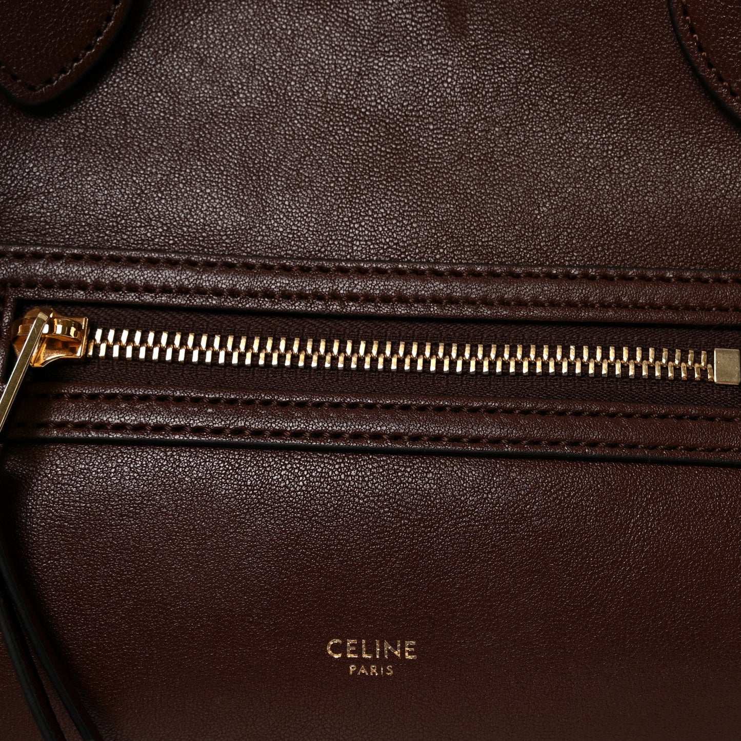 Celine lambskin handbag front zipper with gold-toned pull and stitched leather edge