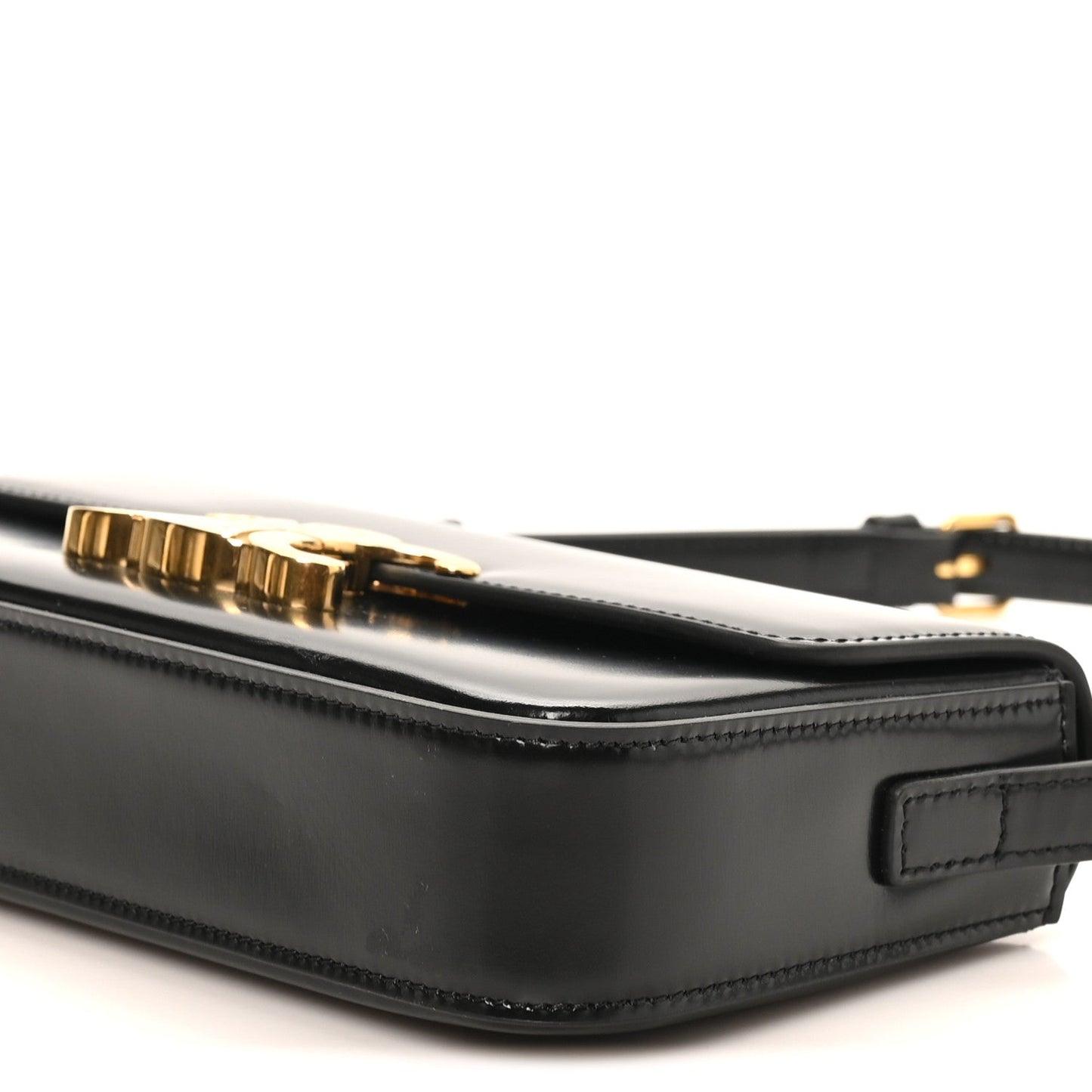 Black leather shoulder bag side view with zipper track and gold-tone hardware bar