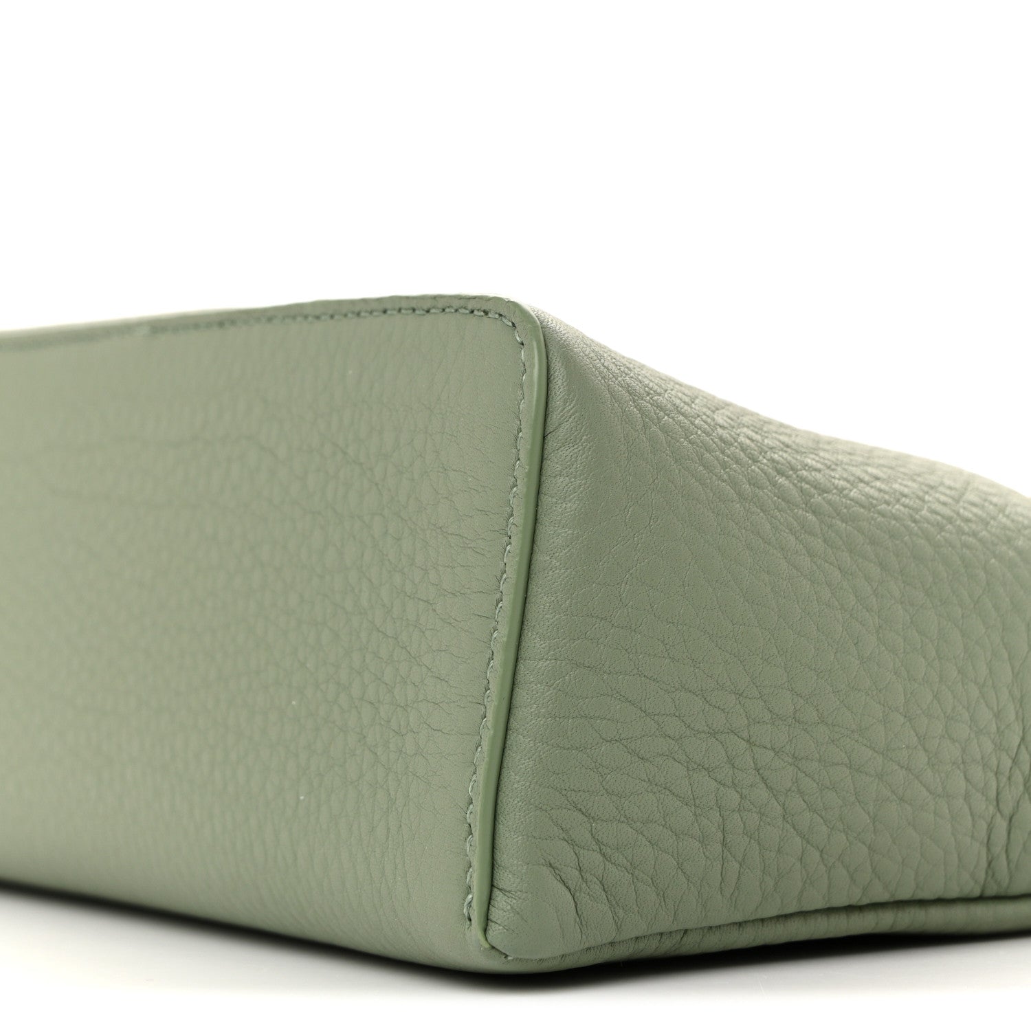 Sage green grained calfskin pouch side panel with edge stitching, close-up