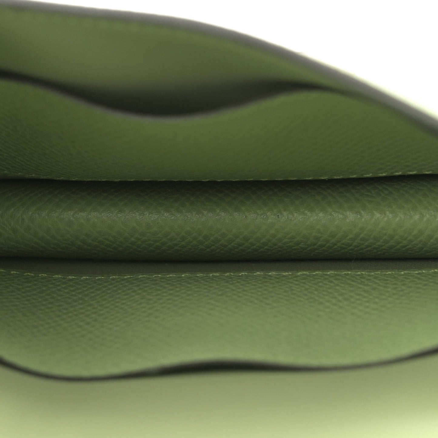 Light green leather wallet interior close-up with curved seam