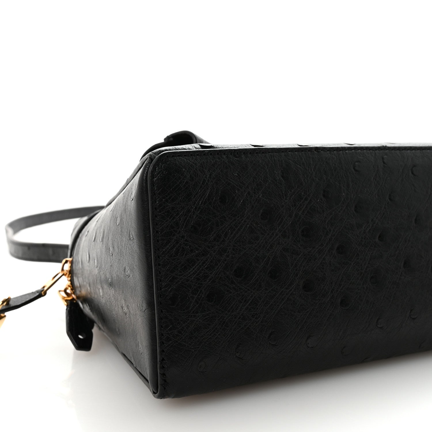 Black ostrich leather mini bag side view with adjustable strap and gold-tone zipper pull