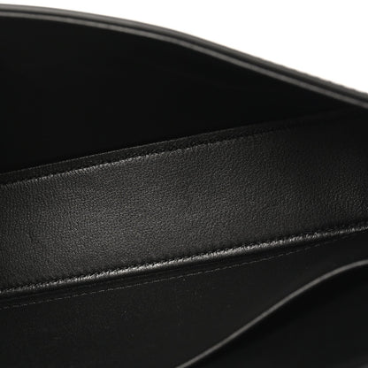 Black shiny calfskin leather close-up with stitched edge and smooth glossy finish