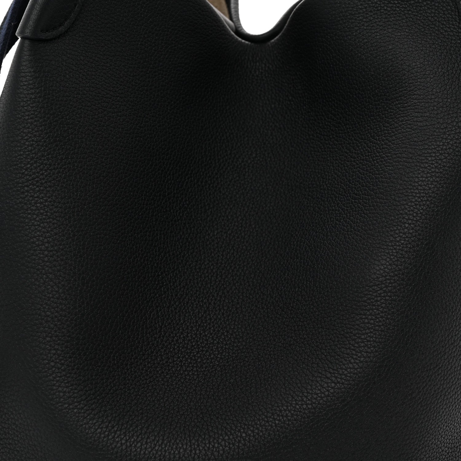 Grained dark navy leather exterior close-up with curved opening and seam