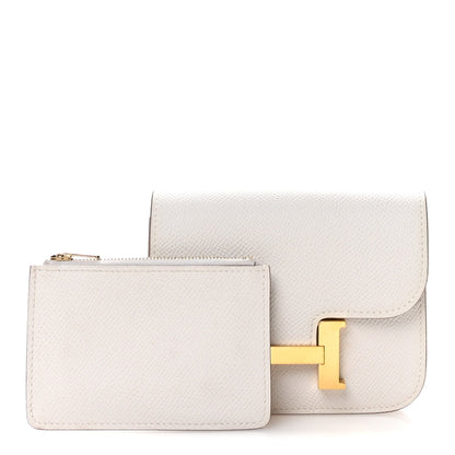 Pale gray slim wallet with flap and gold H clasp, shown with a small matching wallet.