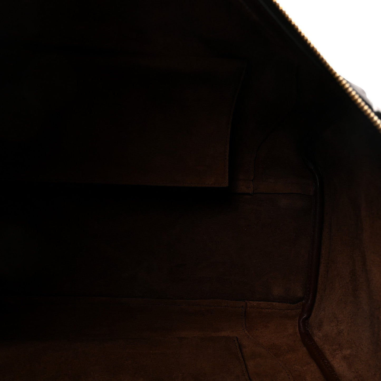 Dark brown leather handbag interior with lining and visible zipper track near opening