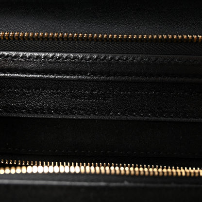Black leather bag with gold zipper and stitched seam detail.