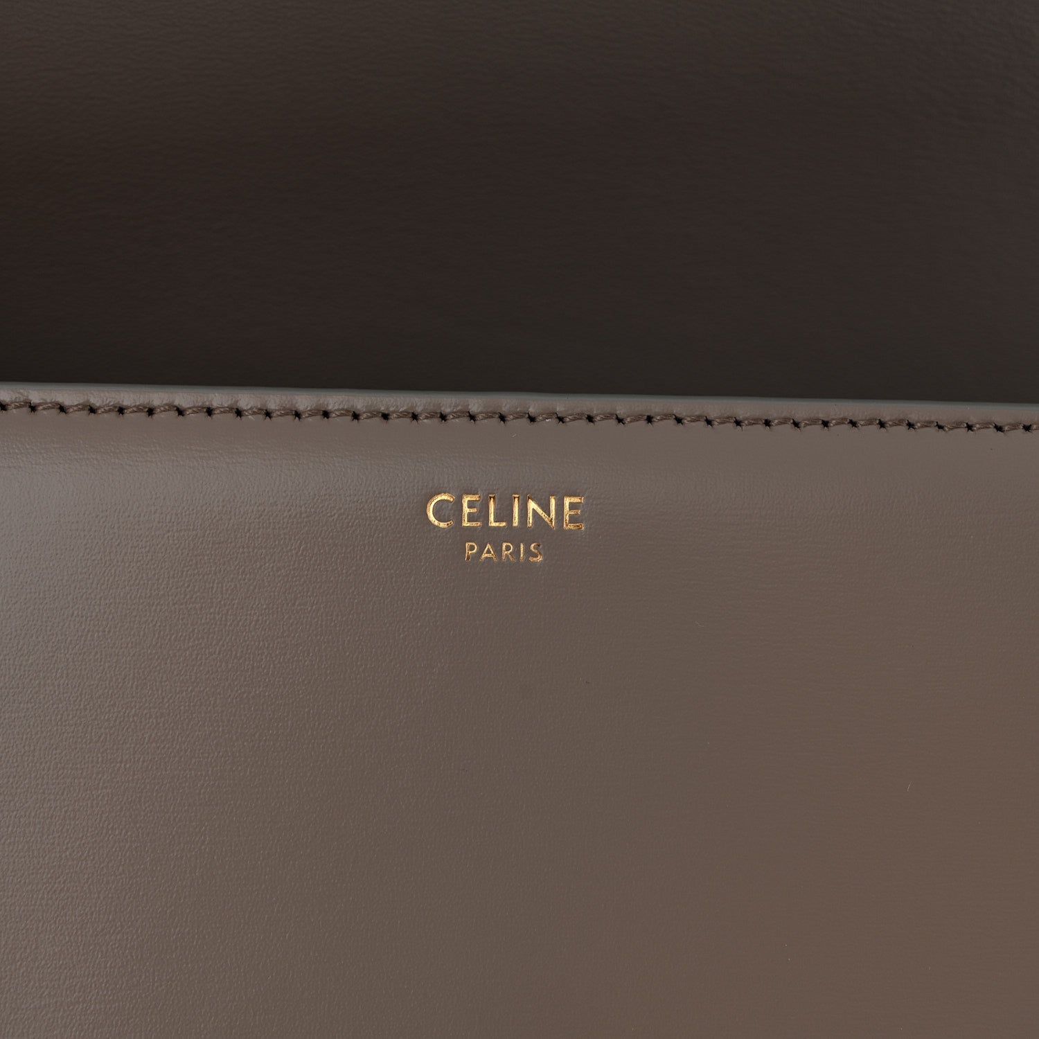 Celine branding on interior of shiny calfskin shoulder bag, gold lettering on dark taupe
