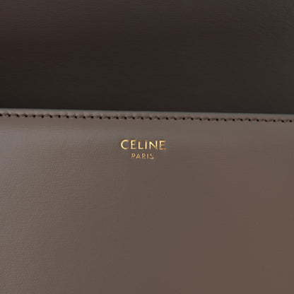 Celine branding on interior of shiny calfskin shoulder bag, gold lettering on dark taupe