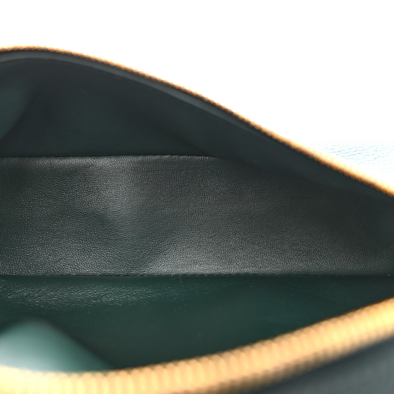 Interior view of dark green leather pouch lining with zipper edge detail.