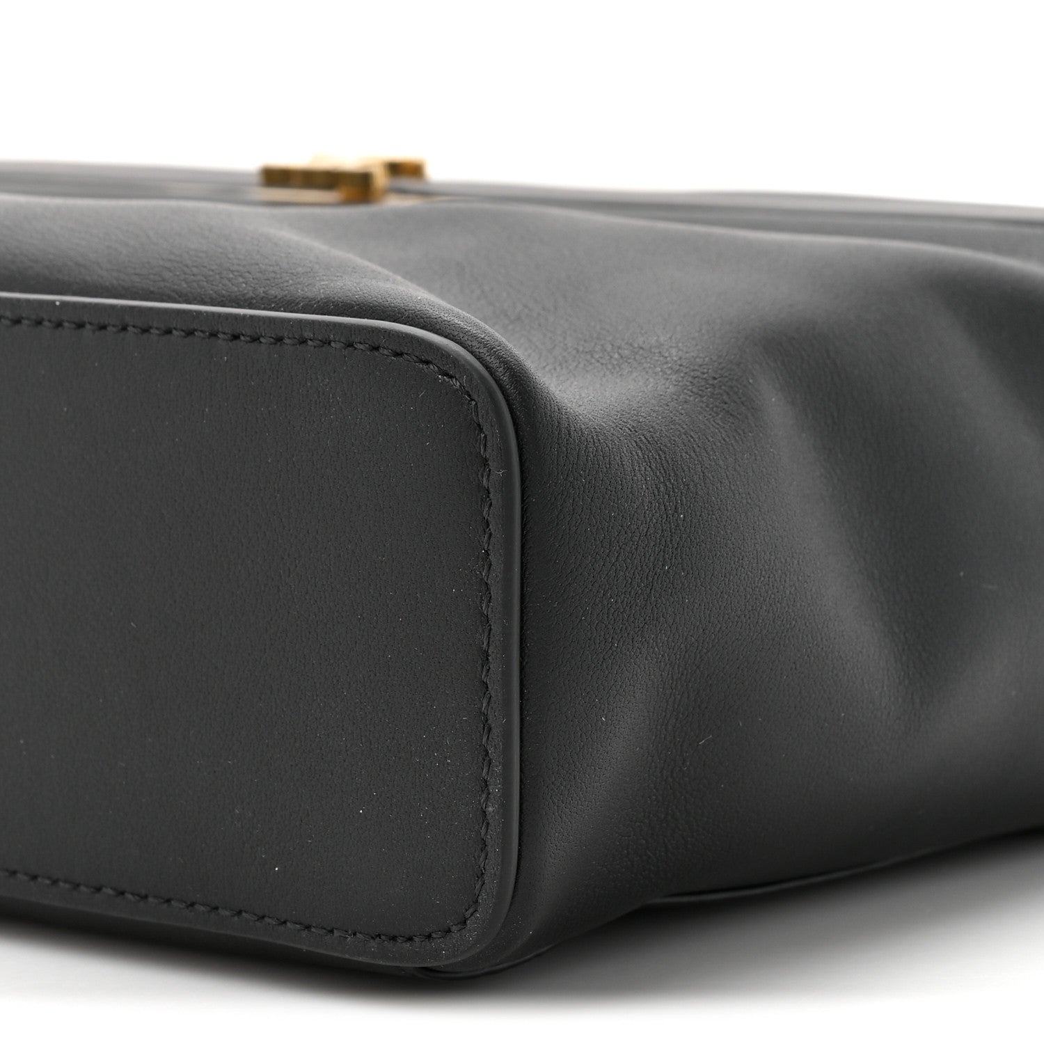 Black leather rectangle bag corner with curved seam and edge stitching
