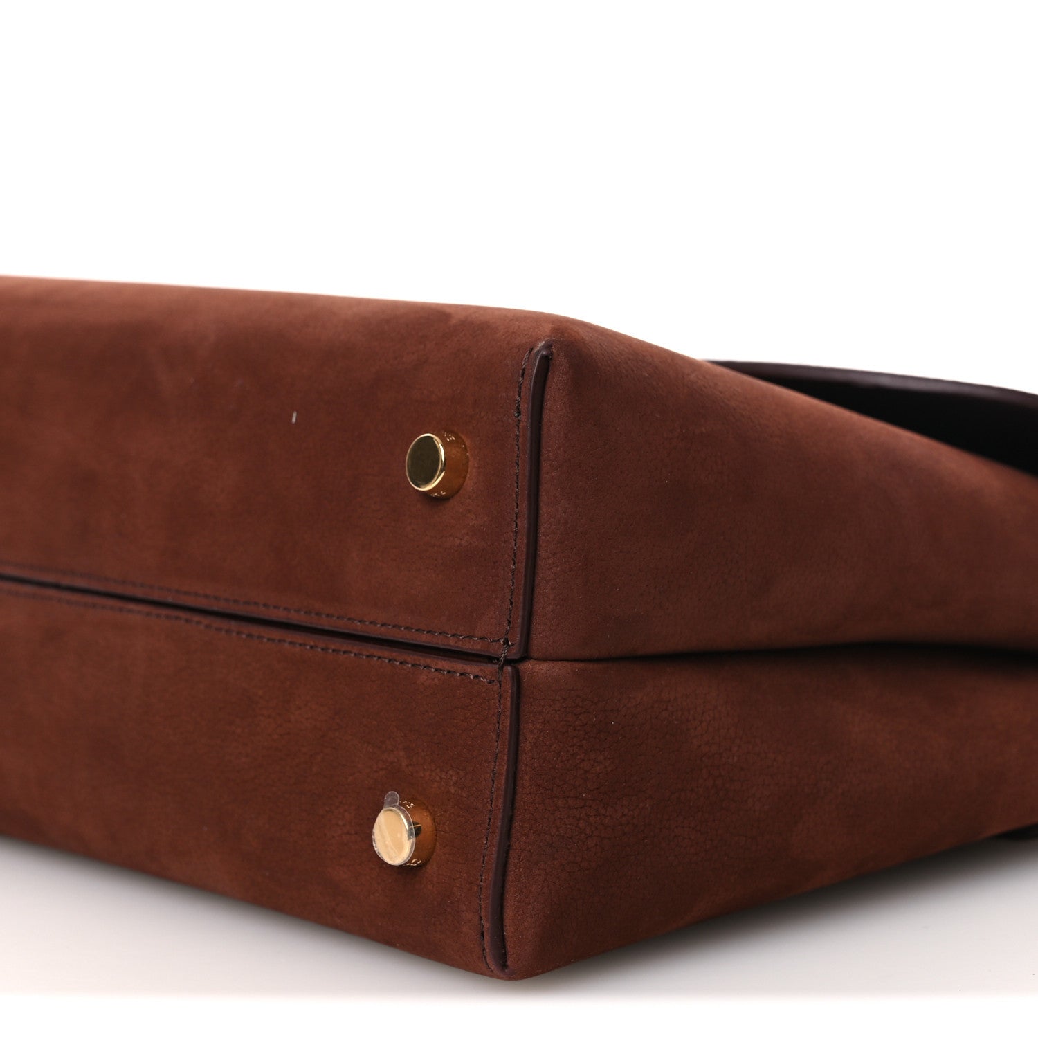 Chestnut brown leather bag corner with gold snap closure and side seam.
