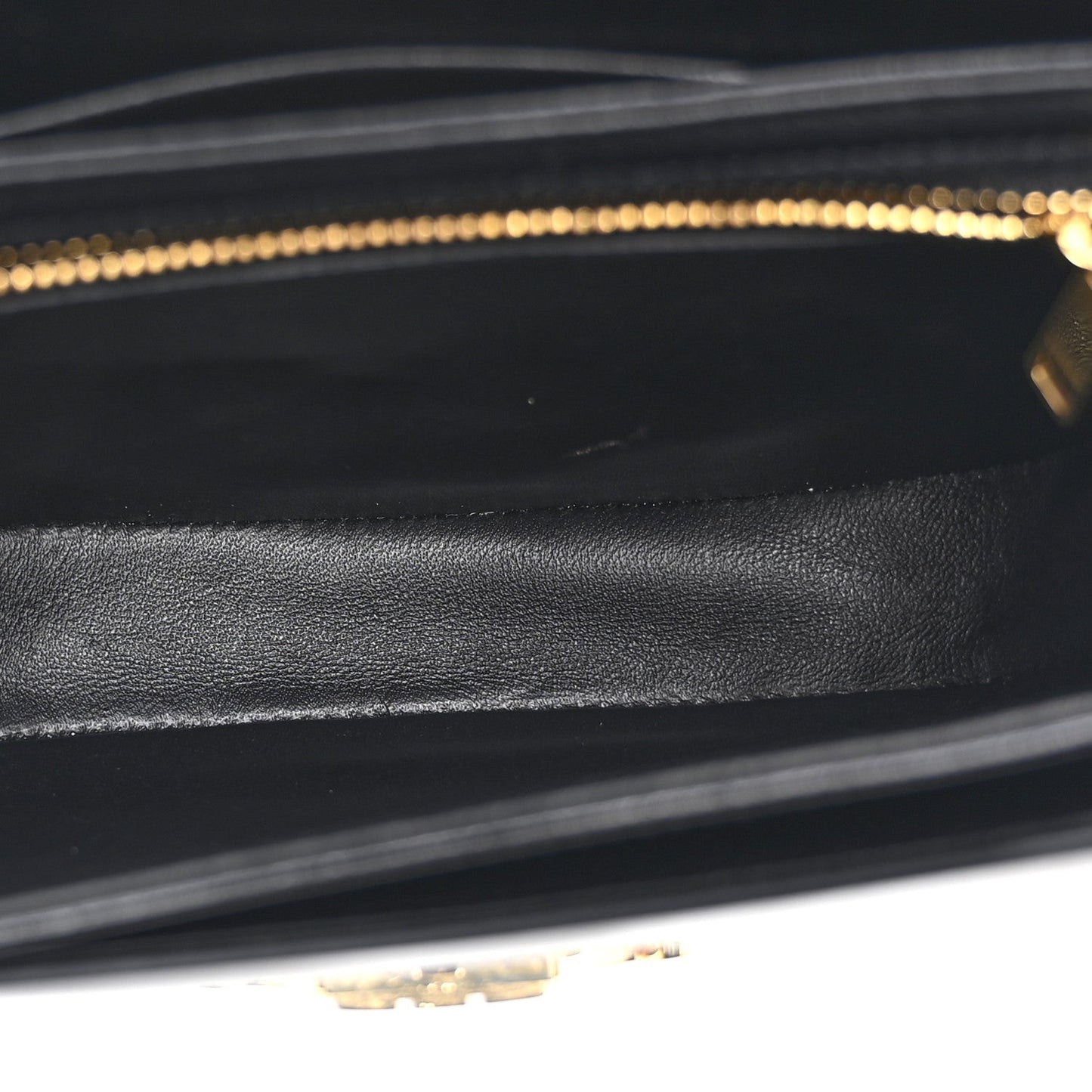 Black leather interior lining with stitched edges and gold-tone zipper track
