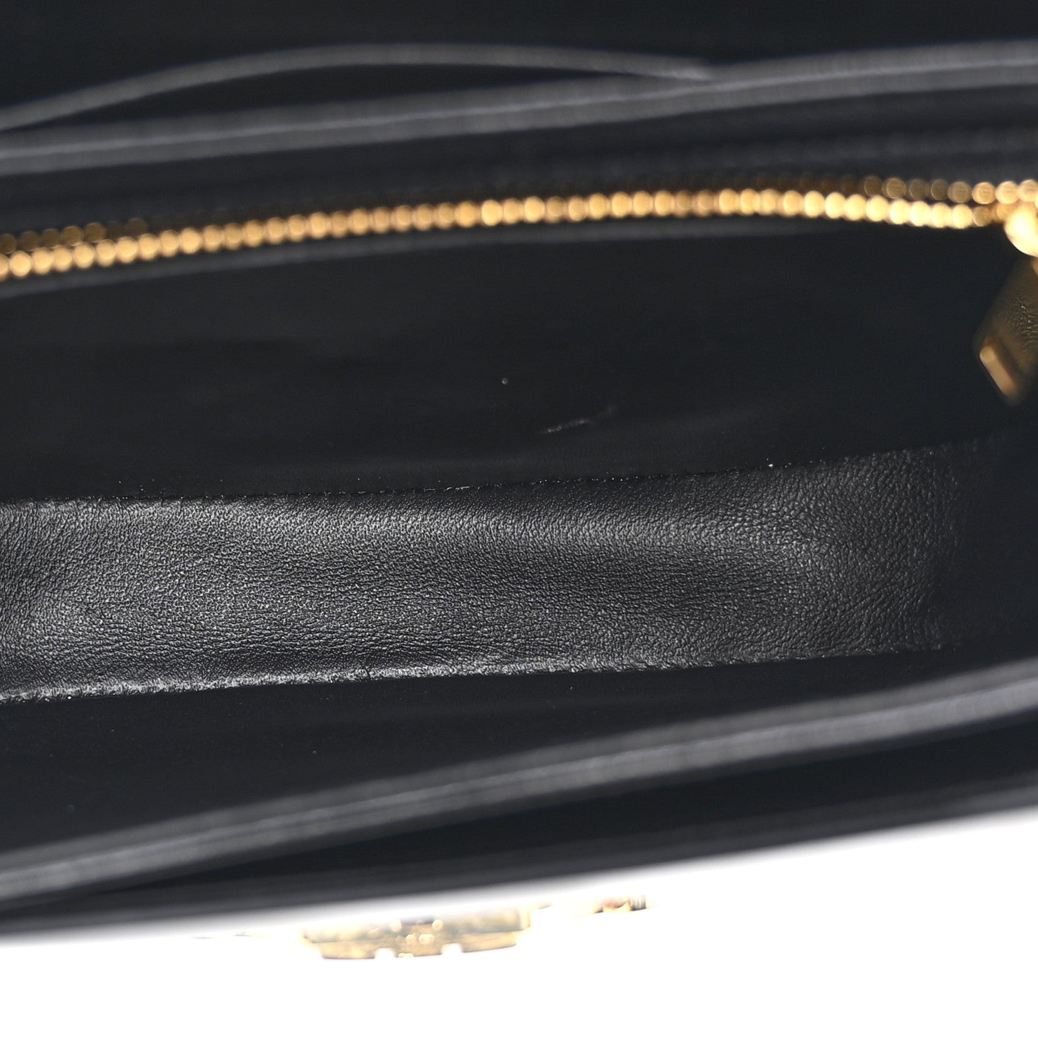 Black leather interior lining with stitched edges and gold-tone zipper track