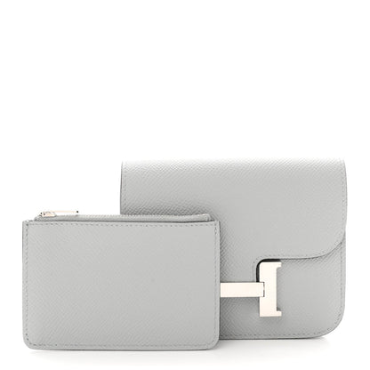 Hermes Constance slim wallet, light blue textured leather, side view with flap and clasp.