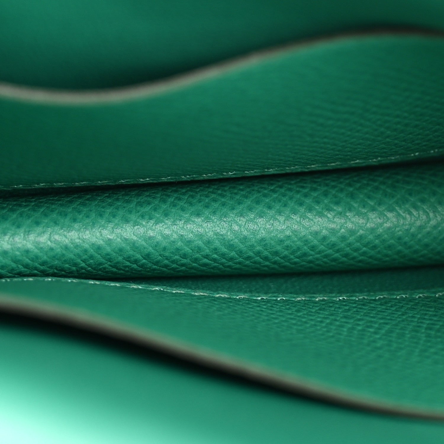 Green leather seam and edge stitching detail with textured grain