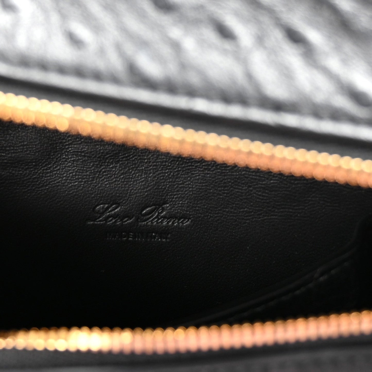 Close-up of black leather interior lining with Loro Piana logo and gold-tone zipper track