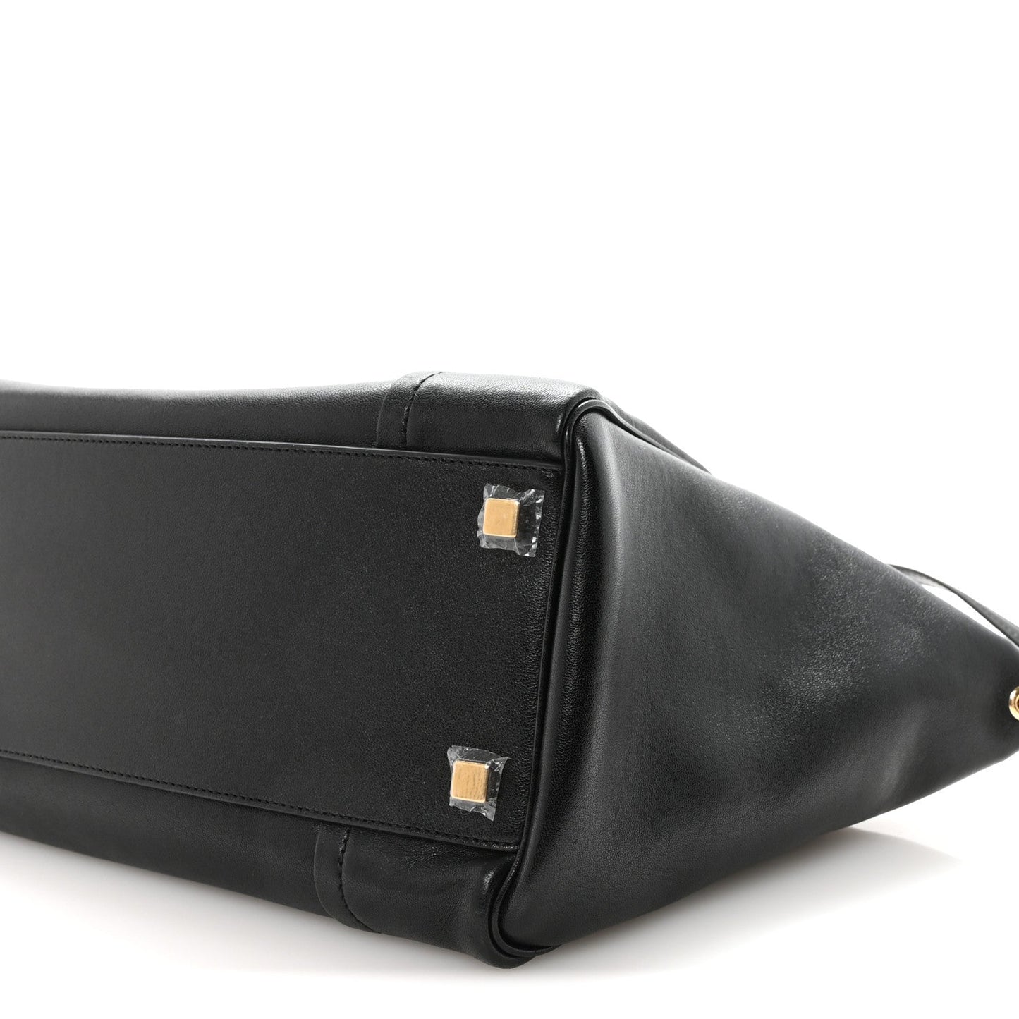 Black leather luggage bag with gold-tone corner hardware and handle.